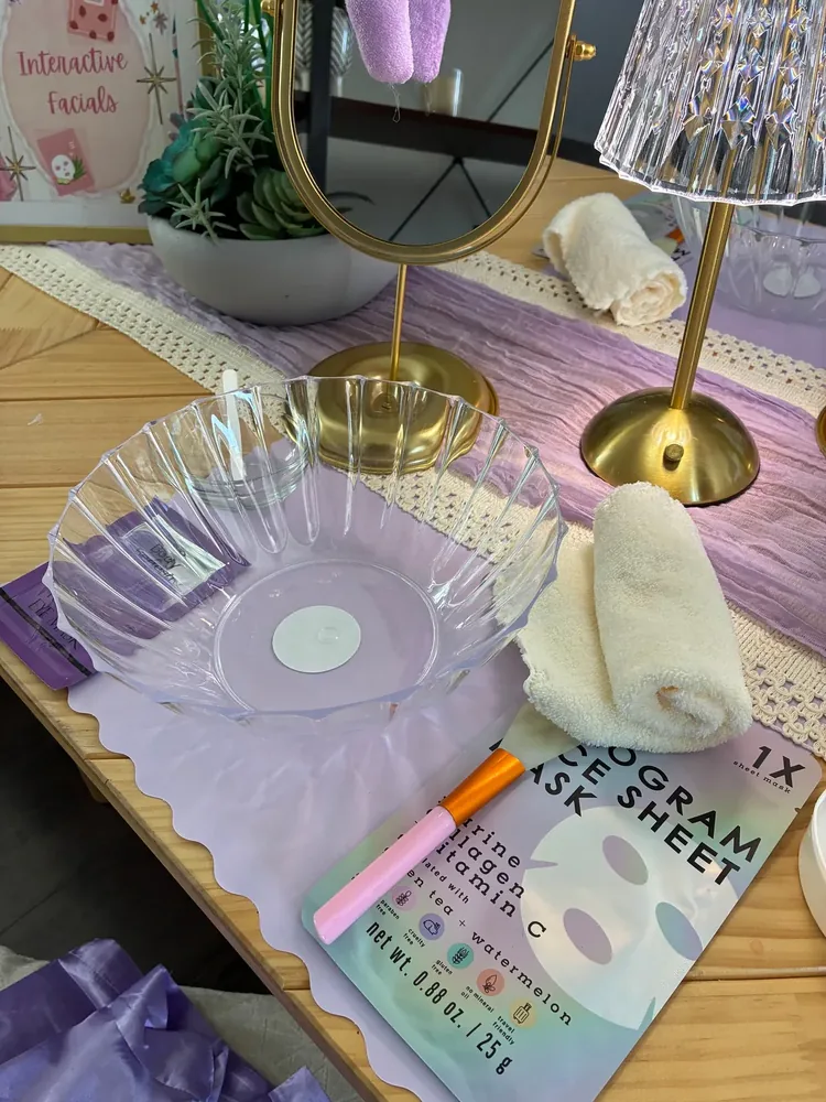 Spa supplies, towels, headwraps, and a mirror arranged on a table.
